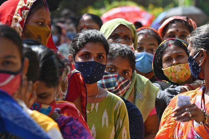 Women in COVID masks in India line up for state elections