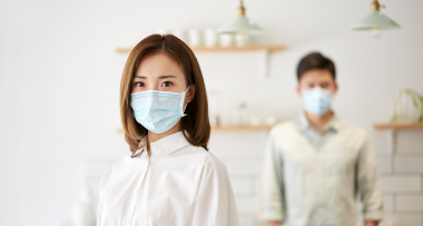 young asian small business owners wearing mask looking at camera -