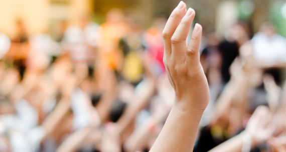 Picture of a raised hand in a crowd 